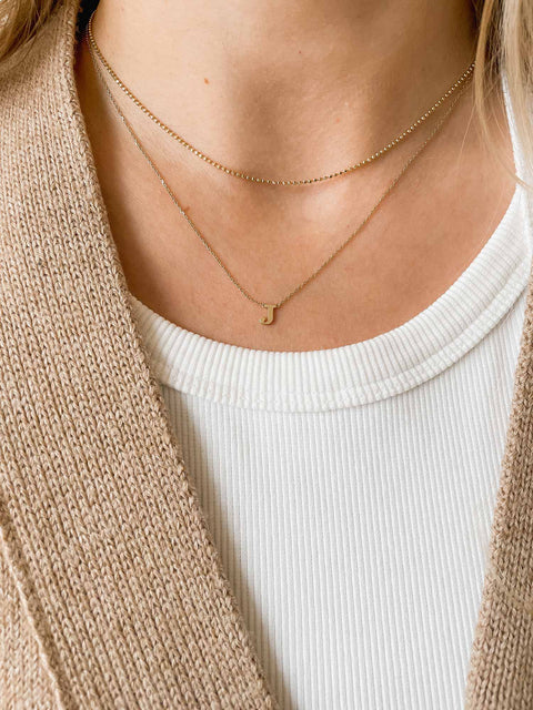 Delicate ball chain necklace in recycled 14k yellow gold with diamond polished surface, 1.1mm link width, 38cm length, made in Germany. Shown layered with an initial necklace.
