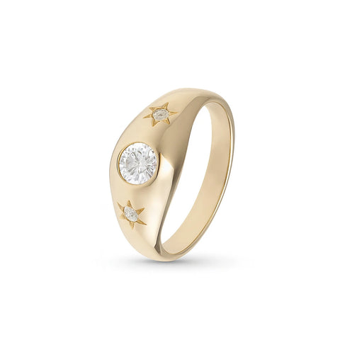 A gypsy-style ring with a glossy polished surface, featuring a white sapphire center stone flanked by two smaller stones, all set in a band with star-shaped settings.