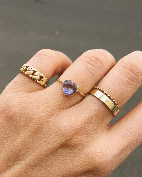 Recycled solid 14k yellow gold ring with 7mm Iolite Heart on 0.9 mm fine wire band, featuring a glossy polished surface. Hand showcasing ring in a ringparty setting.